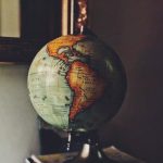 Photographie avec un filtre old school. Un globe terrestre est posé sur une étagère et représente le "tour du monde des initiatives culturelles durant le confinement" proposé dans l'article.