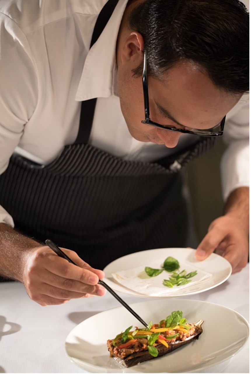 Photo de Guillermo Muro capturant un cuisiner en train de décorer méticuleusement un plat.